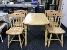 A circular pine drop-leaf kitchen table together with four chairs