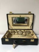 A vintage travel case containing a dressing table set
