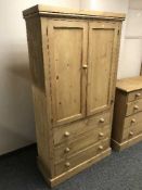 A pine double door cabinet fitted three drawers