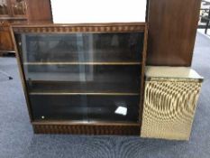 A mahogany sliding glass door bookcase together with a loom glass topped linen box