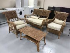 A three piece cane conservatory suite, cane coffee table,