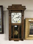 An oak wall clock with silvered dial,