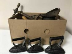 A box containing vintage hand pump, flat irons,