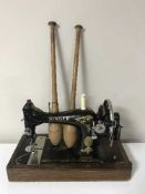 An oak cased hand Singer sewing machine and a pair of wooden juggling clubs