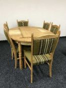 A blonde oak oval extending table with two leaves and eight dining chairs