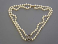 A fine double strand pearl choker necklace with old cut diamond pendant and gold clasp,