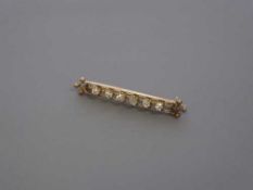 A six stone diamond set yellow gold bar brooch, width 48mm, 5g.