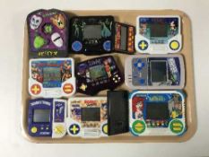 A tray containing assorted electronic hand held games including Sonic the Hedgehog,
