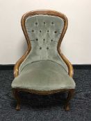 A reproduction lady's chair in green button fabric