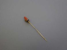 A Victorian gold pin with coral finial with entwined serpent