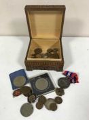 A carved trinket box of assorted British coins, American dollar & half dollar, WWII medal,