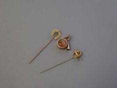Two gold brooches and a gold pendant,