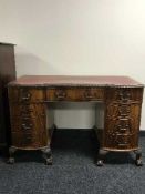 A shaped mahogany twin pedestal desk on claw and ball feet inset red leather panel