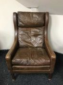 A brown leather wing back chair