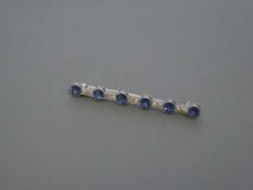 An early twentieth century six stone sapphire and diamond bar brooch, set in white gold,
