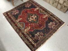 A fringed Persian wool rug on blue ground