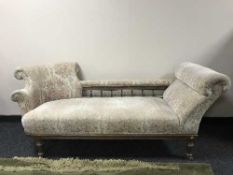 A chaise longue upholstered in cream floral upholstery