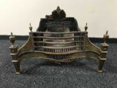 An early 20th century ornate brass and cast iron fire grate