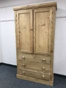 A pine double door cabinet fitted with three drawers