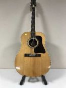 A Kaywai acoustic guitar on stand