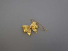 An 18ct gold diamond set bow brooch, 12.