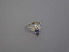 A pear-cut tanzanite and three stone diamond ring