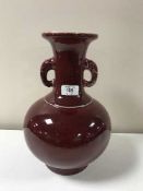 A Chinese sang de boeuf baluster vase with elephant mask handles, character mark to base,