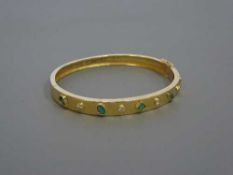 A 9ct gold emerald and diamond bangle, 19.