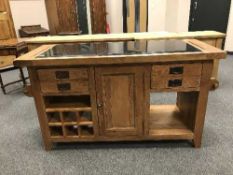 A contemporary oak kitchen work bench with black granite top