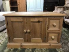 A pine TV stand fitted cupboard and drawers beneath