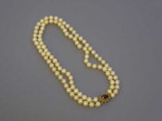 A cultured pearl choker necklace with 9ct gold garnet set clasp, length 37 cm.
