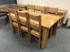 A contemporary oak dining table and six chairs with tan leather seats