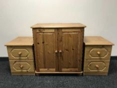 A pine double door cupboard and a pair of pine effect bedside chests