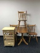A pine drop leaf table and three chairs plus a pine effect kitchen trolley