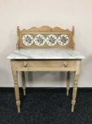 A stripped pine marble topped wash stand with tiled splash back