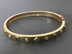 A 9ct gold emerald and diamond bangle, 19.