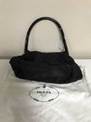 A Prada black nylon handbag, with sectional round plastic handle, 28 cm wide,