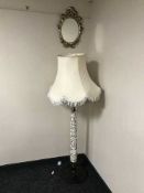 A decorative mahogany standard lamp with shade together with an ornate gilt framed mirror