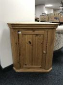 A stripped pine panel door hanging corner cabinet