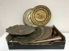 A box of assorted copper and brass plaques and trays, copper measures,