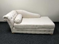 A contemporary chaise longue bed settee upholstered in a beige fabric