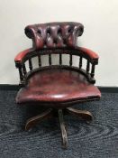 A red button leather Chesterfield swivel armchair