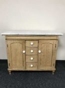 An early 20th century pine marble topped sideboard with white ceramic handles
