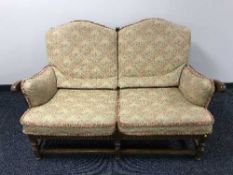A two seater Ercol settee in multi coloured print