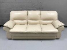 A cream leather three seater settee