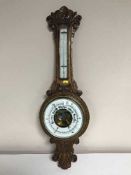 A carved oak cased banjo barometer