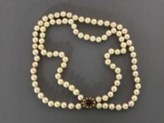 A cultured pearl choker necklace with 9ct gold garnet set clasp, length 37 cm.