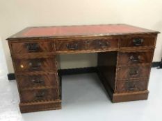 A mahogany twin pedestal writing desk fitted nine drawers with red leather inset panel