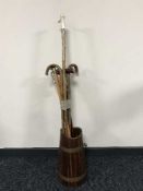 A wooden copper bound stick stand and bundle of walking sticks and a shooting stick