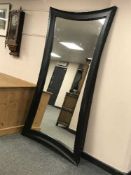A black contemporary wavy edged mirror,